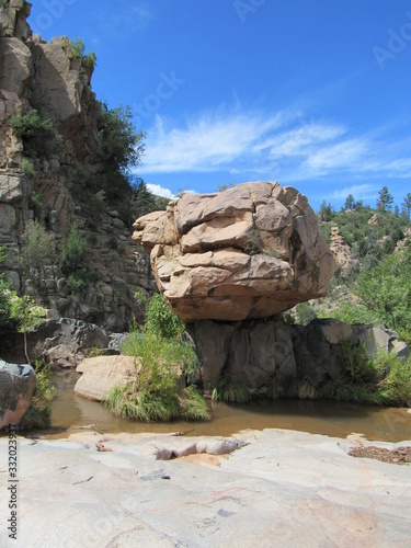 Giant boulder balanced on top of another rock formation seen on the Water Wheel Falls hiking trail in Payson, Arizona 