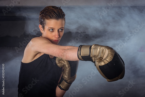 Closeup image of a female boxer practicing punching with boxing gloves © qunica.com