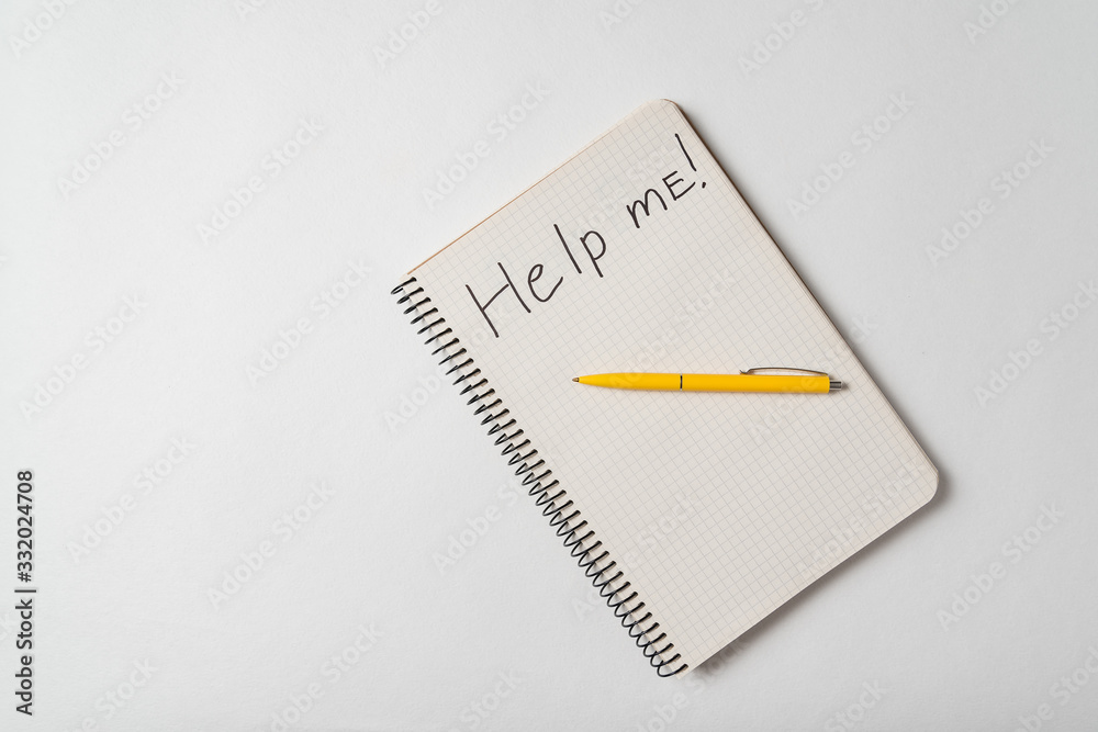Top view of the notepad with Help Me notice on a white background. Request for assistance sos Top view of the notepad with Help Me notice on a white background. Request for assistance sos