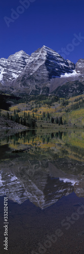 Panoramic view of autumn colors of Aspens reflecting in lake under Maroon Bells, Colorado, near Aspen