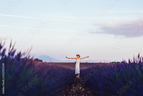 Picturesque landscape of beautiful nature environment with purple flowers, happy woman enjoying solo holidays for visiting Provence vast area with scenic lavandula field against breathtaking sky