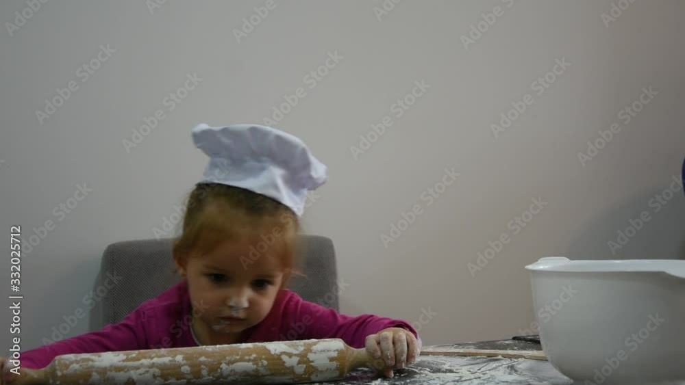 Little Girl, cock chef in decorating Christmas cookies in the kitchen Little Girl, cock chef in decorating Christmas cookies in the kitchen