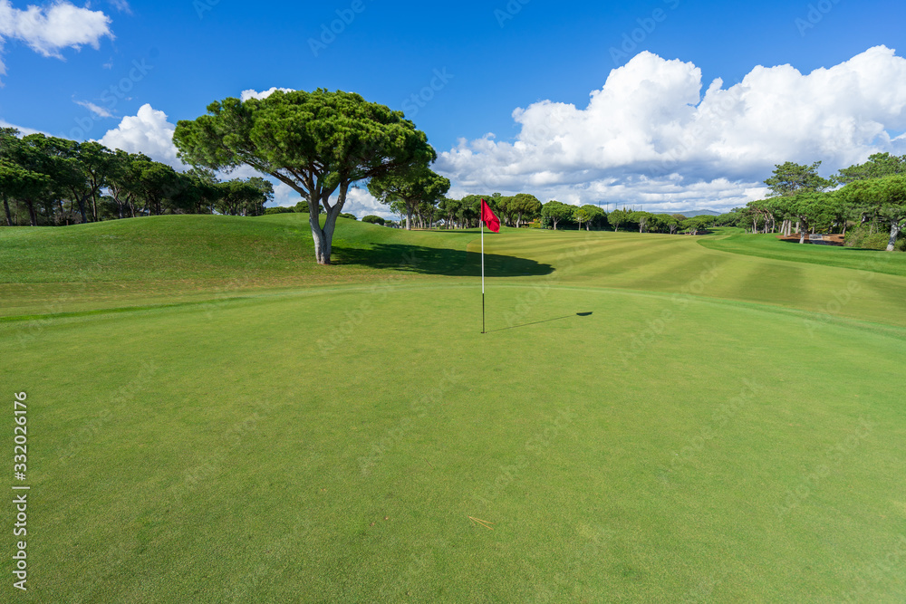 Beautiful, empty golf course with blue sky and green grass Beautiful, empty golf course with blue sky and green grass