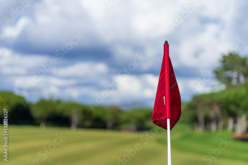 Red flag on a green golf course field