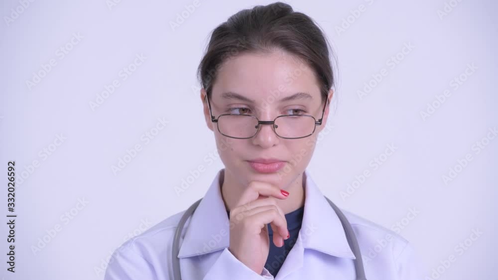 Face of serious young woman doctor thinking and looking down Face of serious young woman doctor thinking and looking down