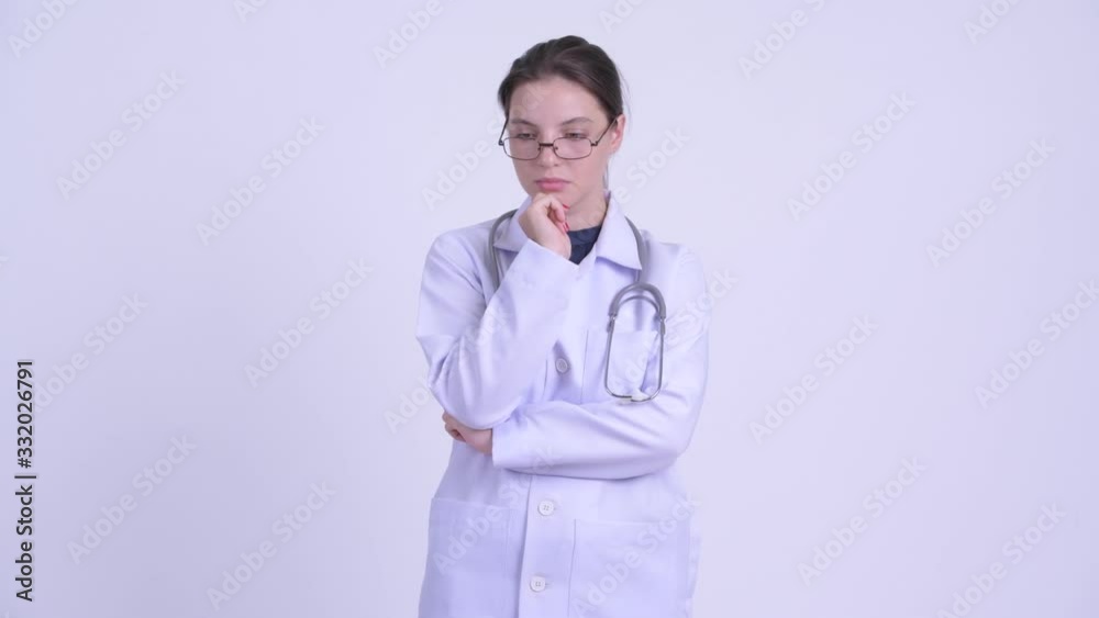 Serious young woman doctor thinking and looking down Serious young woman doctor thinking and looking down
