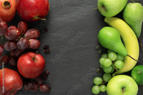 fruits background green and red color set, dark stone slake plate with copy space. Flat lay top view. Summer abstract creative trendy fresh concept.