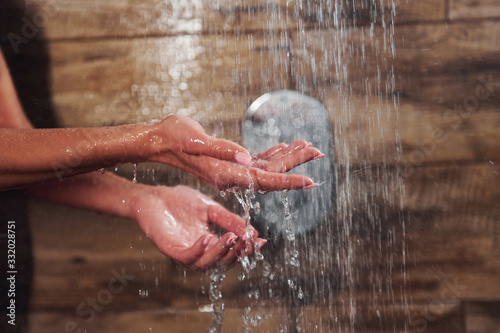 Close up view of hands of woman that taking a shower in spa