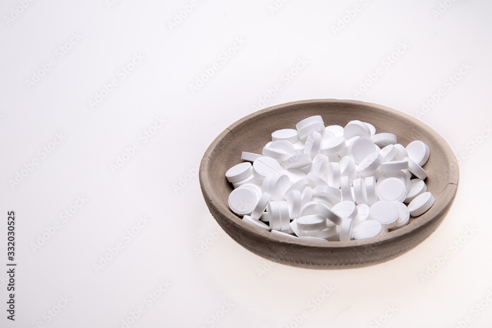 White tablets on a clay plate. White tablets on a clay plate.