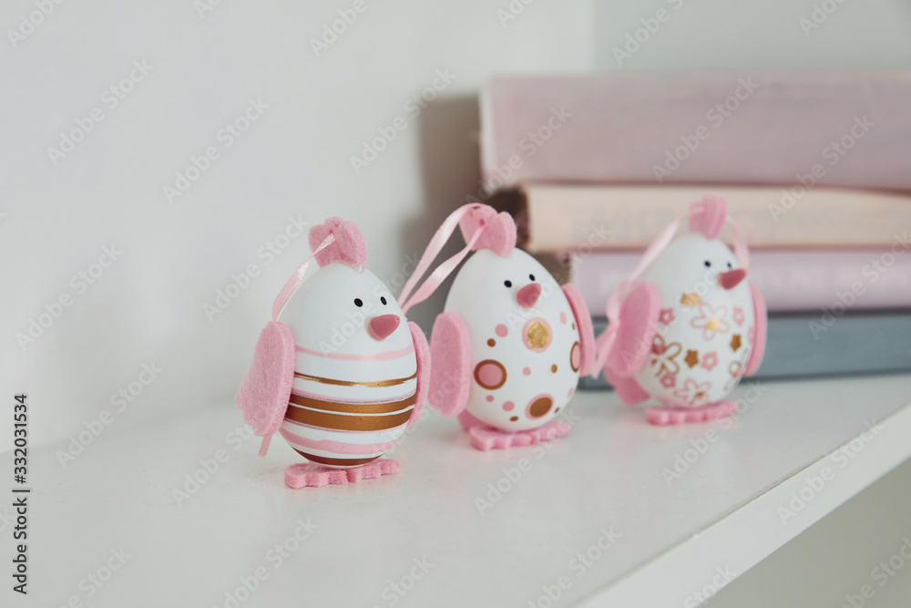 Close up view of cute painted with pink color Easter eggs on shelves indoors Close up view of cute painted with pink color Easter eggs on shelves indoors