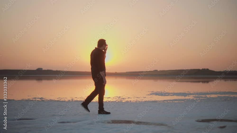 young man walking on the lake in sunset young man walking on the lake in sunset
