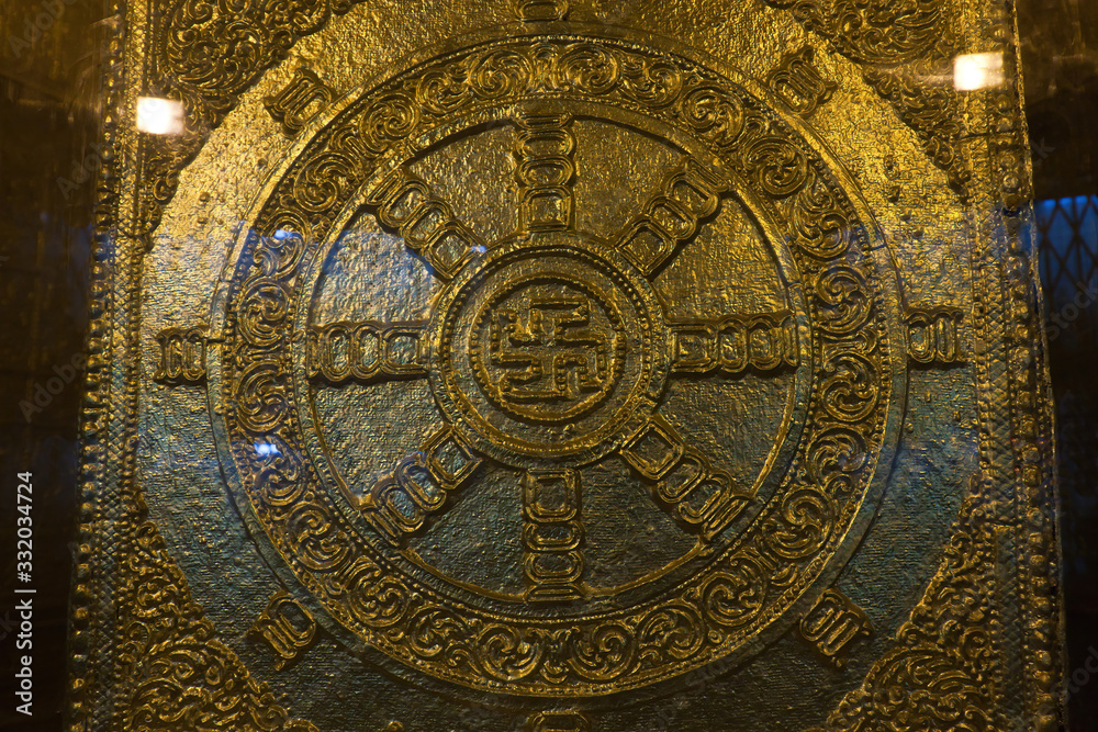 The gold plated Buddhist swastika decoration near the Buddha relics in the Botahtaung Pagoda, Yangon, Myanmar