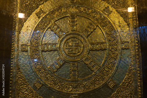 The gold plated Buddhist swastika decoration near the Buddha relics in the Botahtaung Pagoda, Yangon, Myanmar photo