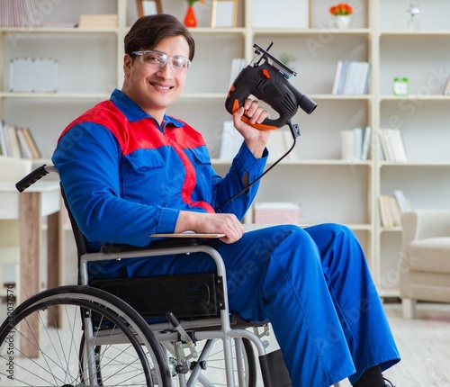 Disabled man working with handsaw at home