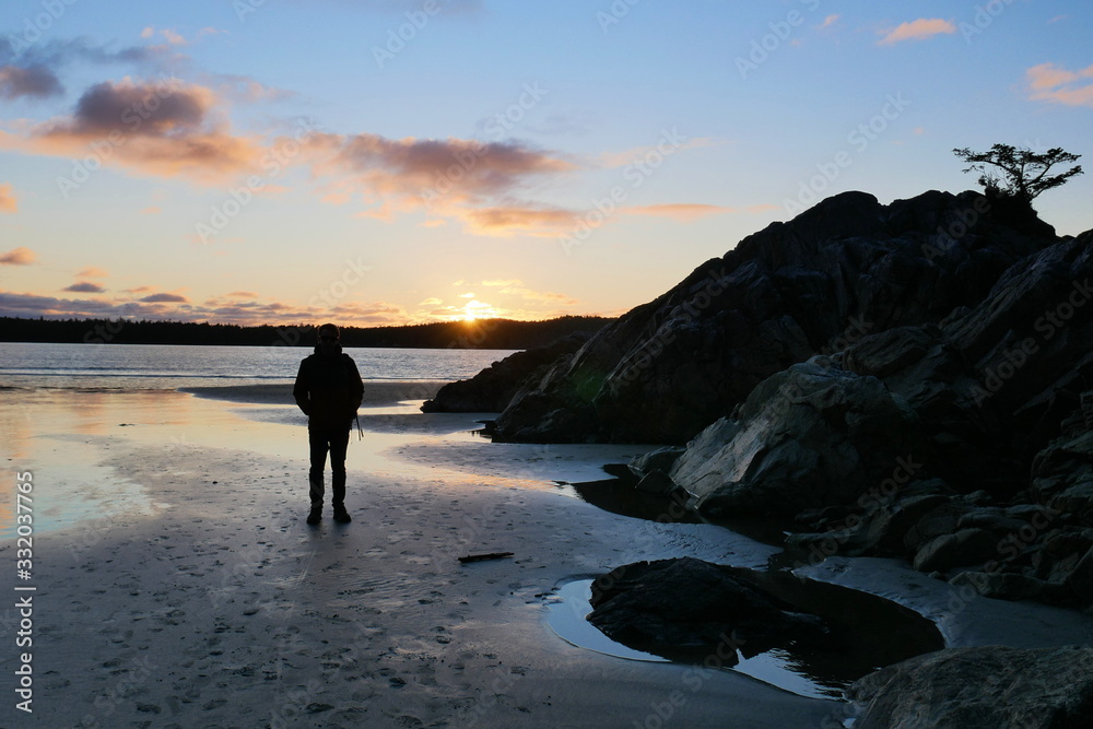 Silhouette of lone man watching sunset