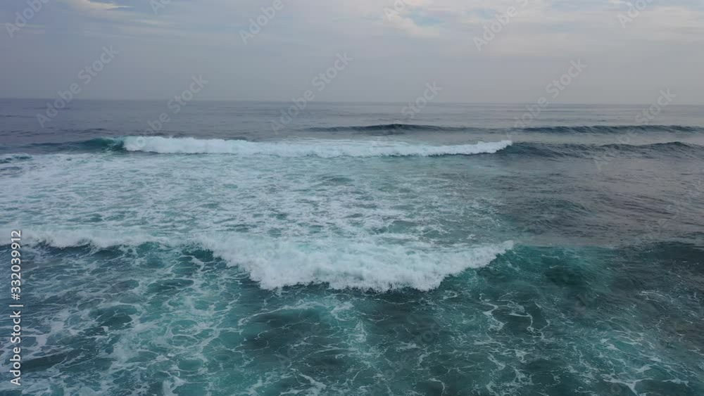 4K aerial view of a large beautiful Pacific wave from a height. Surfing on smooth rolling beautiful long waves. Sea blue, green charming water. Travel around the world. The bewitching beauty of nature 4K aerial view of a large beautiful Pacific wave from a height. Surfing on smooth rolling beautiful long waves. Sea blue, green charming water. Travel around the world. The bewitching beauty of nature