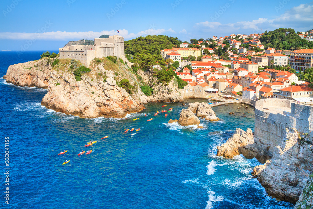 Summer mediterranean cityscape - view of the the Fort Lovrijenac and harbor with a group of kayaks, the Old Town of Dubrovnik, on the Adriatic coast of Croatia