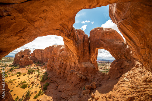 Stunning view of Double Arch in Arches National Park, Utah in the summertime with blue sky background. Travel, tourism, desert landscape area in popular road trip area. photo