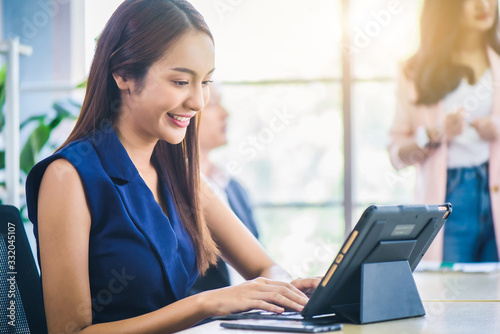 Business woman using digital tablet to see financial data and analyzing report graph while meeting at office. Teamwork meeting and partnership conference working concept.