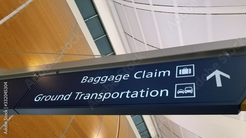 Airport signage showing baggage claim and ground transportation for passengers at arrival hall