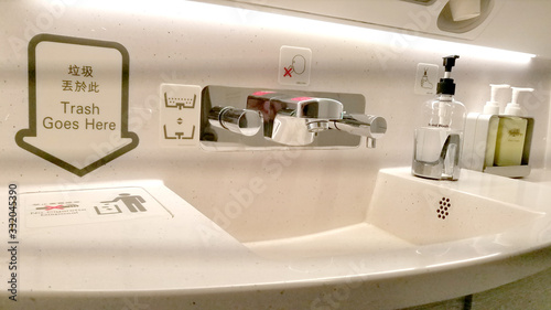 Bathroom sink in a commercial airplane with personal cleaning products