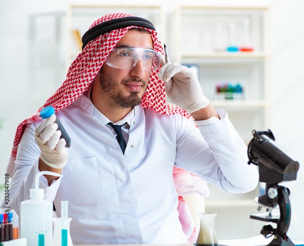 Naklejka premium Arab chemist working in the lab office