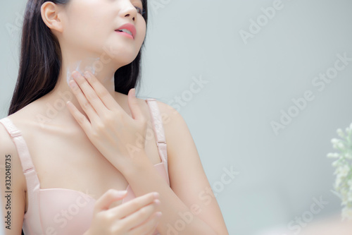 Beautiful sexy young asian woman looking mirror applying cream on neck and message  beauty girl applying body lotion skin care for health and soft hydration  treatment and cosmetic with moisturizer.