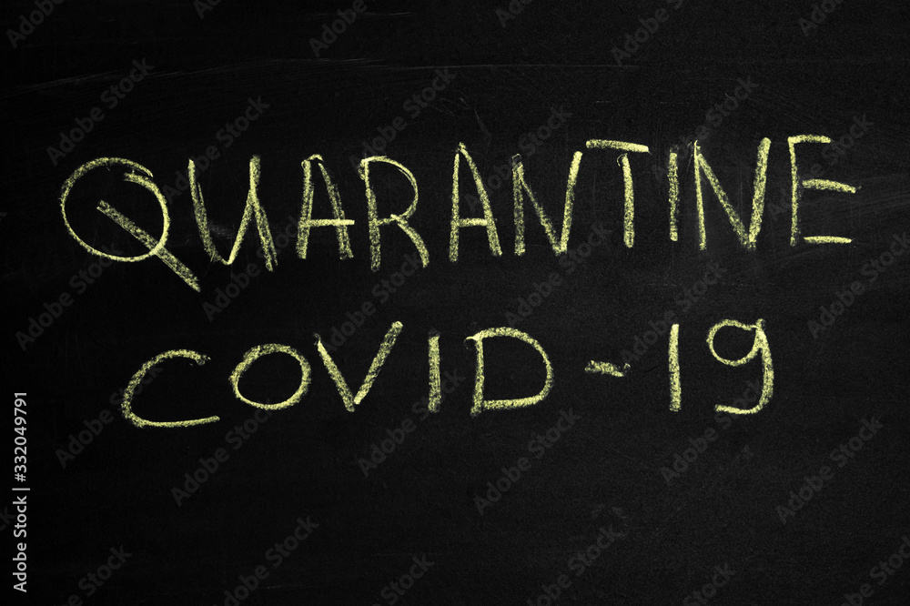 Fototapeta premium The inscription Quarantine and covid19 on a black board. Yellow chalk