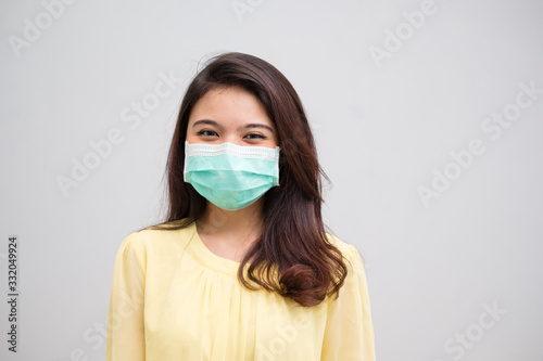 Portrait of a cheerful and healthy young woman asian wearing medical mask. Pandemic 2019 Coronavirus 2019-nCoV Concept.