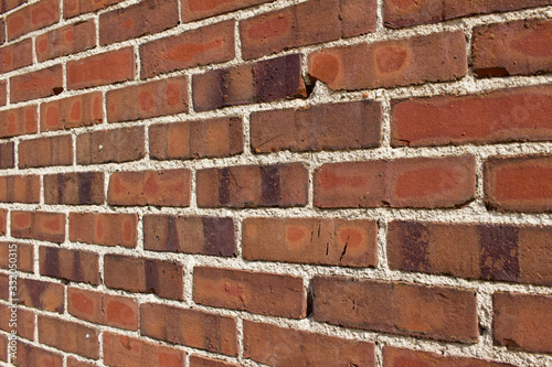 Shabby chic old brown and red brick wall texture with light colored mortar (angle view)