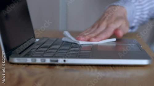 Close-up scene: woman cleaning keyboard of laptop with wet wipes. against Novel coronavirus or Corona Virus Disease (Covid-19). Antiseptic, Hygiene and Healthcare concept. photo