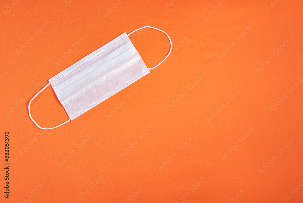 Surgical mask over minimalist orange background Surgical mask over minimalist orange background