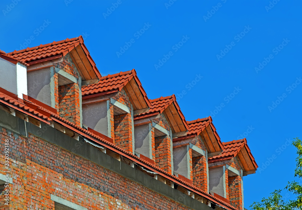red brick tile roof with triangle windows line on blue sky in sunny day, construction diversity red brick tile roof with triangle windows line on blue sky in sunny day, construction diversity