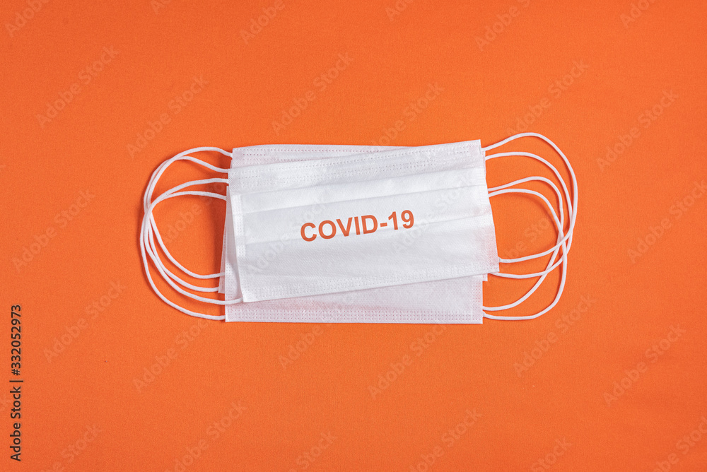 Surgical mask over minimalist orange background Surgical mask over minimalist orange background