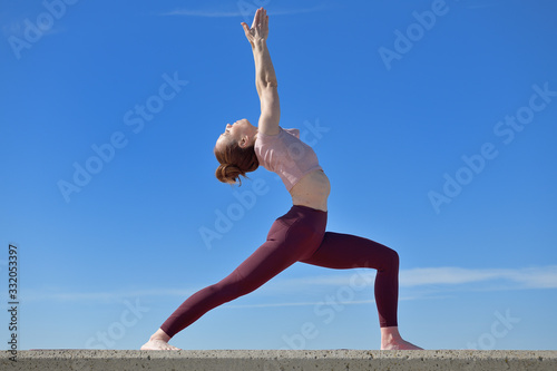 Portrait of a fit woman who practices yoga outdoors. Woman practicing asanas on a sunny day