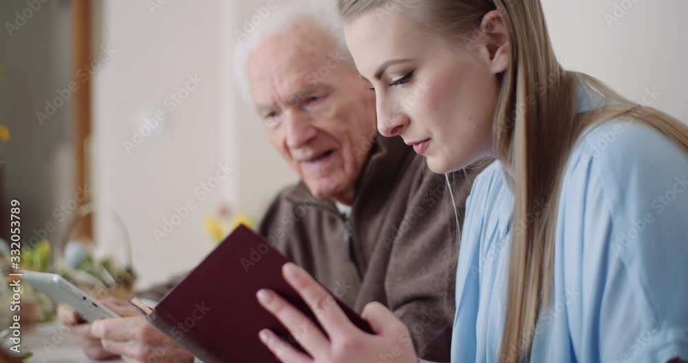 Young Woman Surfing Internet with Grandfather on Digital Tablet Young Woman Surfing Internet with Grandfather on Digital Tablet