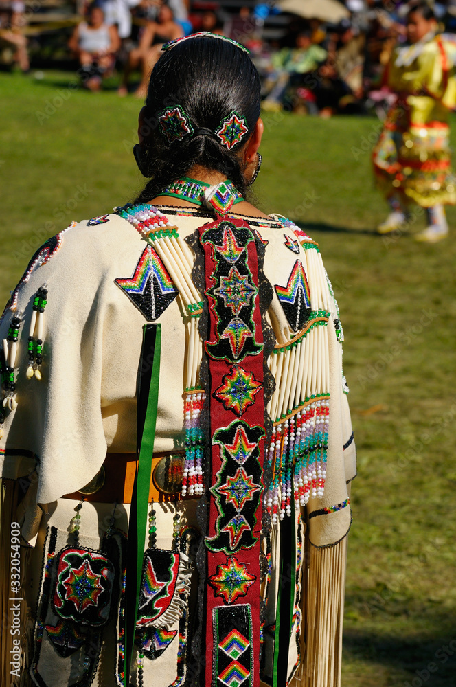 Fototapeta premium Native Indian woman in traditional buckskin regalia judging a dance competition at a Pow Wow