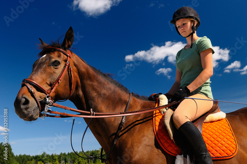 Female rider mounted on her thoroughbred horse outdoors before a training session © Reimar