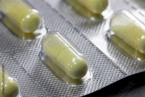 Yellow round pills in a package on a black background. photo