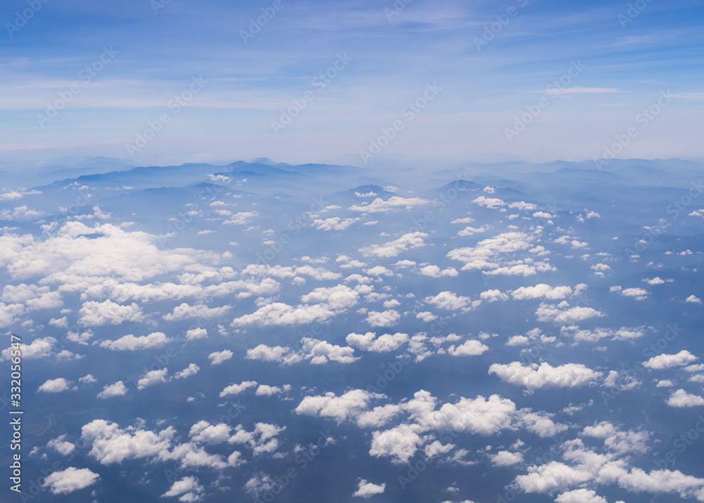 Fototapeta premium Aerial shot of blue sky with clouds and mountain view from plane