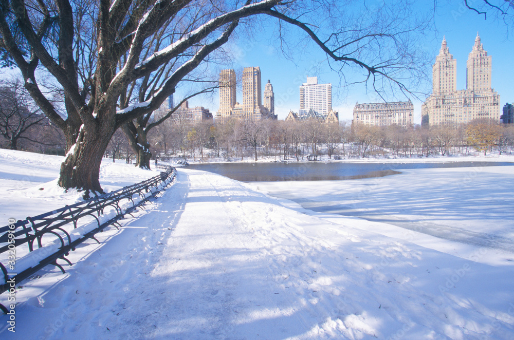Park benches with snow in Central Park, Manhattan, New York City, NY after winter snowstorm