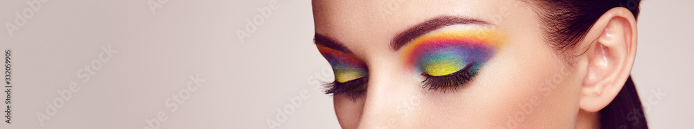 Female eye with  rainbow make-up.  Long eyelashes, vivid colorful eyeshadows. Beauty. Close up, Macro - obrazy, fototapety, plakaty 