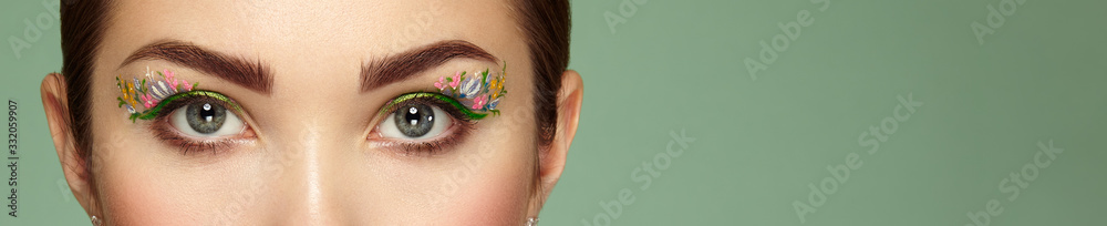 Fototapeta Female eye with flower makeup eyes. Spring makeup. Beauty fashion. Eyelashes. Cosmetic Eyeshadow. Make-up detail. Close up, Macro