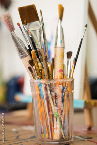 Fototapeta Naklejka Na Ścianę i Meble -  Used paint brushes in glass