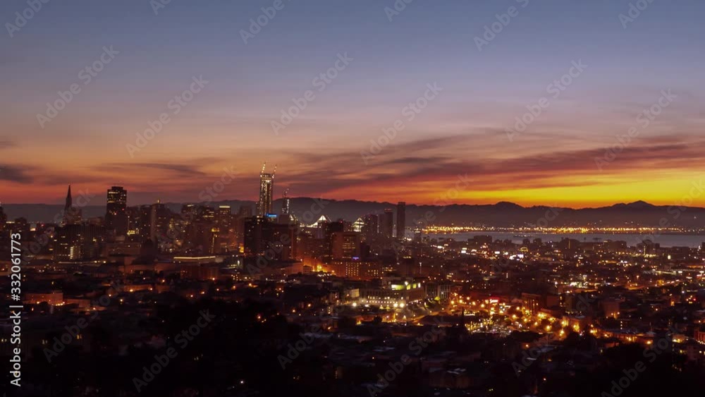 Beautiful city of San Francisco California aerial pink, orange, yellow and blue sky sunrise timelapse from on top of a hill as night traffic and street lights fade as the sun rises over the hills. Beautiful city of San Francisco California aerial pink, orange, yellow and blue sky sunrise timelapse from on top of a hill as night traffic and street lights fade as the sun rises over the hills.