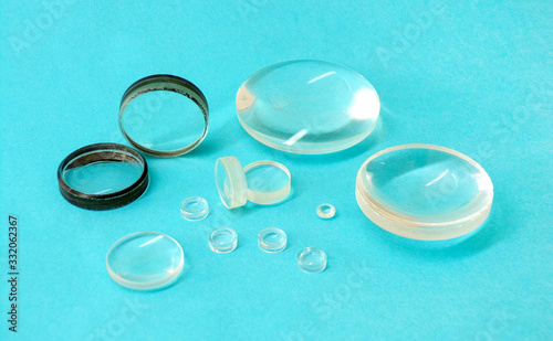 Magnifying lenses close- up on a blue background. Spare parts for optical devices. Optical lens magnifier made of glass and plastic.