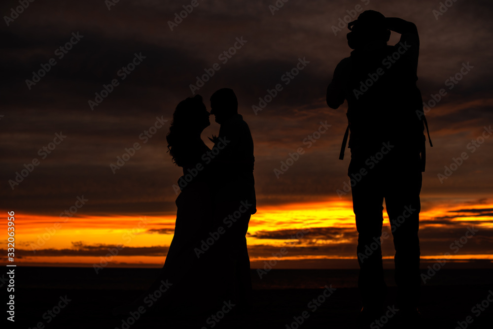 Romantic portrait of the silhouette of a couple on a beautiful sunset at the beach