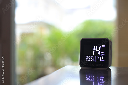 air quality sensor placing on a table indoor. sensor found small amount of air pollution of PM 2.5 the poisonous harmful particulate matter invisible dust from open field fire. man-made disasters. photo