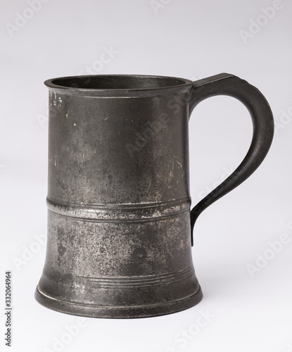 Принти на полотні An old antique 19th Century hallmarked  English pewter beer tankard on a white background
