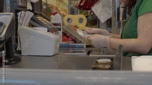 Close up checkout counter in the supermarket during coronavirus epidemic. Senior customer's hands giving cash to the cashier. COVID-19 pandemic